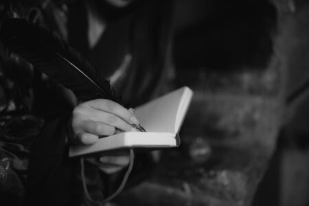 Woman writing in notebook with pen, representing authentic creative expression