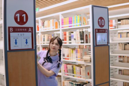 Young Asian woman reading book in contemplative pose