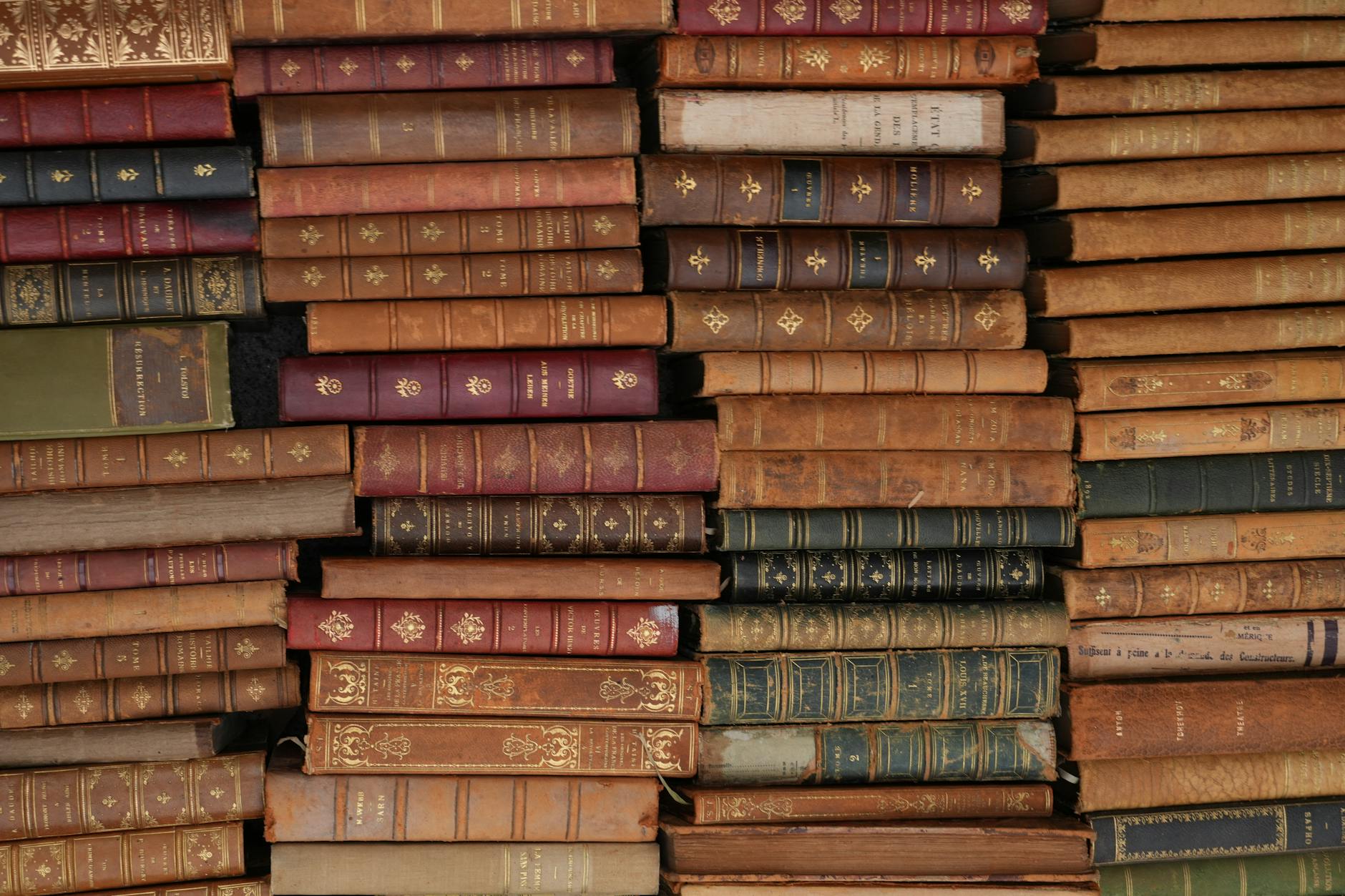 Stack of classic literature books on wooden surface
