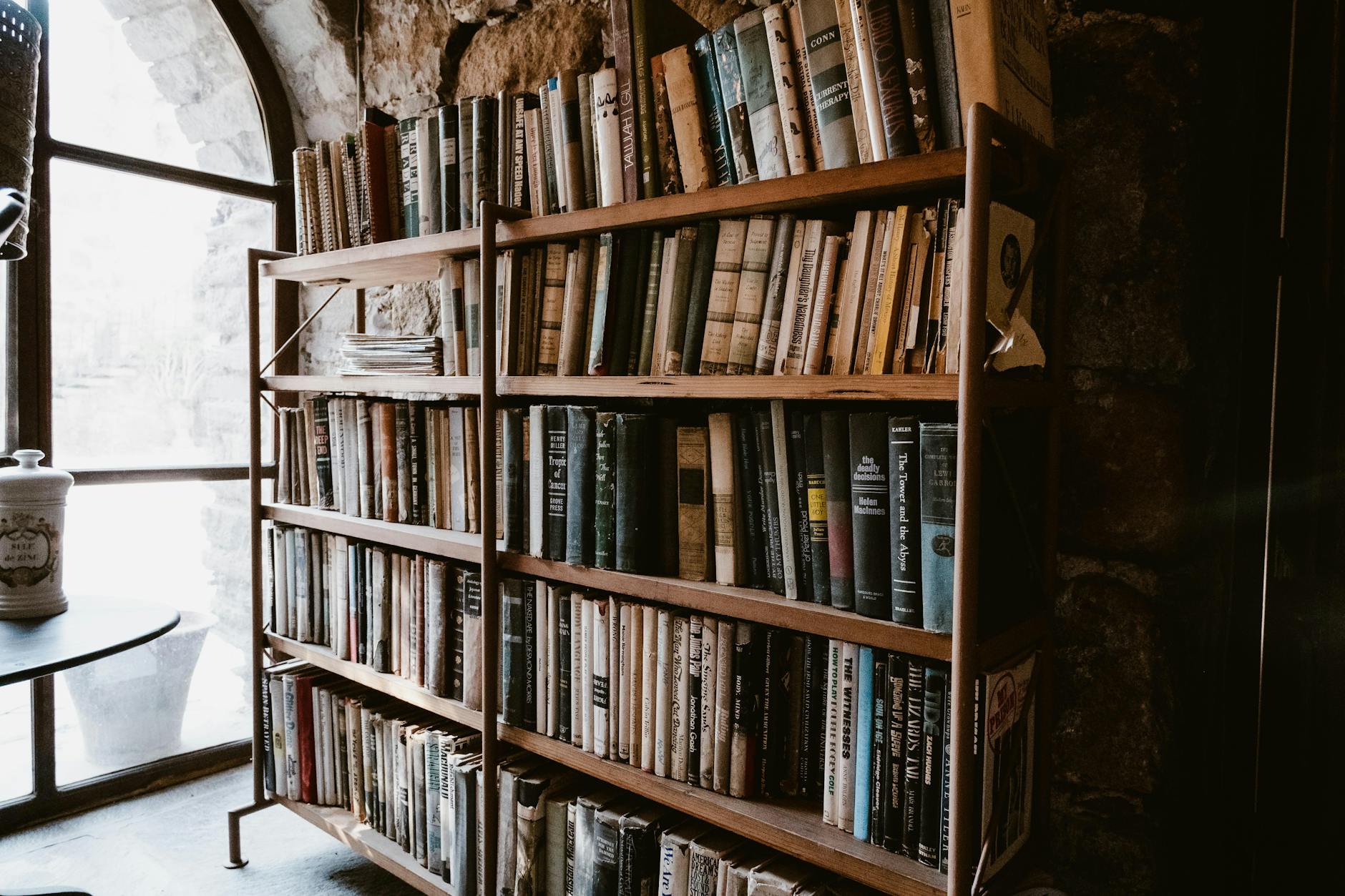 Rows of aged hardcover books on wooden library shelves