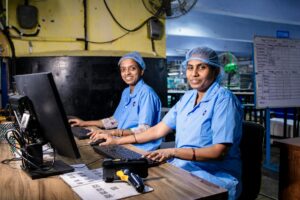 Office workers using computers and digital tools at desks