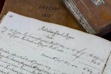 Vintage books and manuscripts on wooden desk representing 19th century literary family