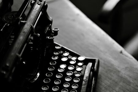 Close-up of vintage typewriter keys and paper, representing literary creation