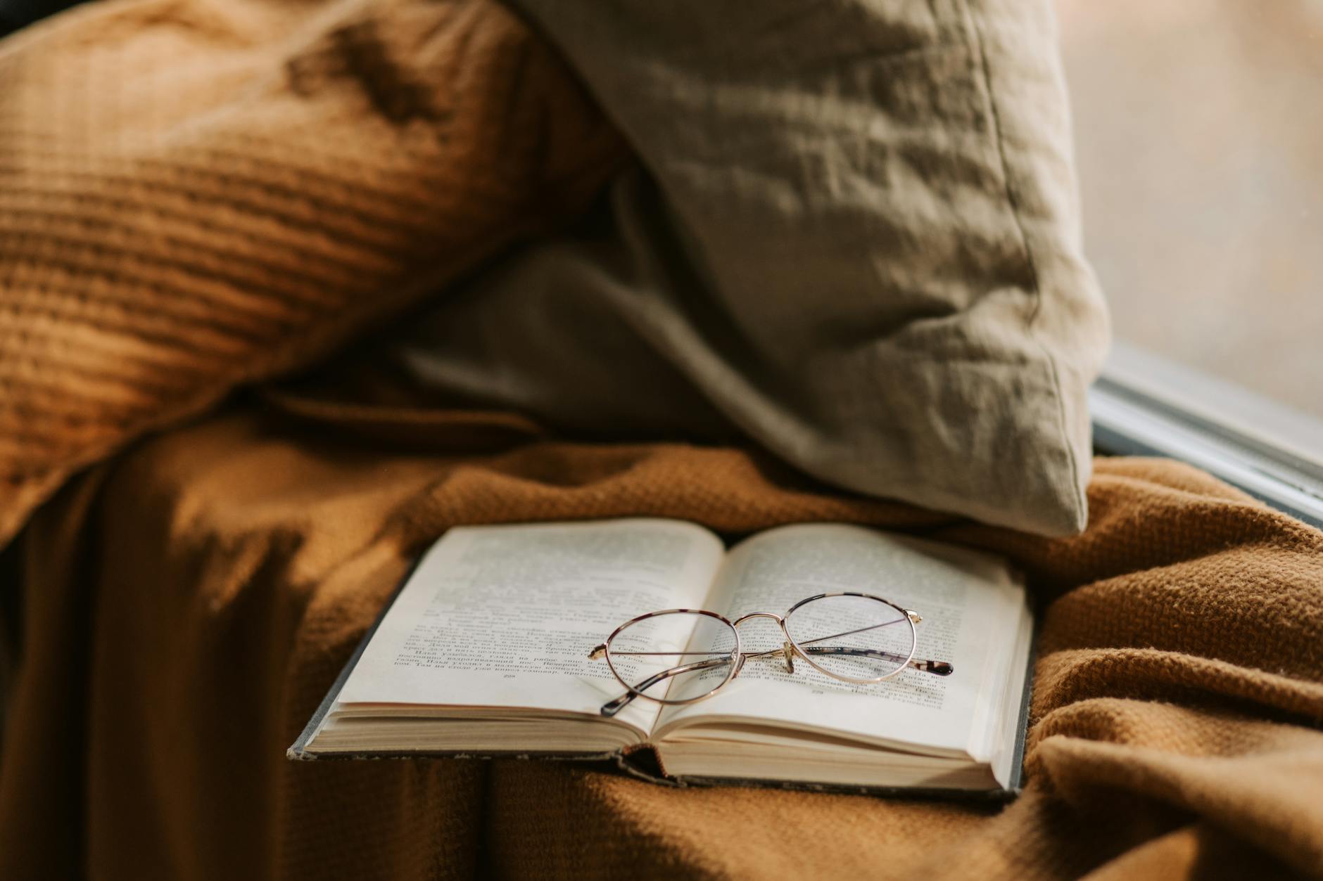 Open book resting on a windowsill with soft light coming through