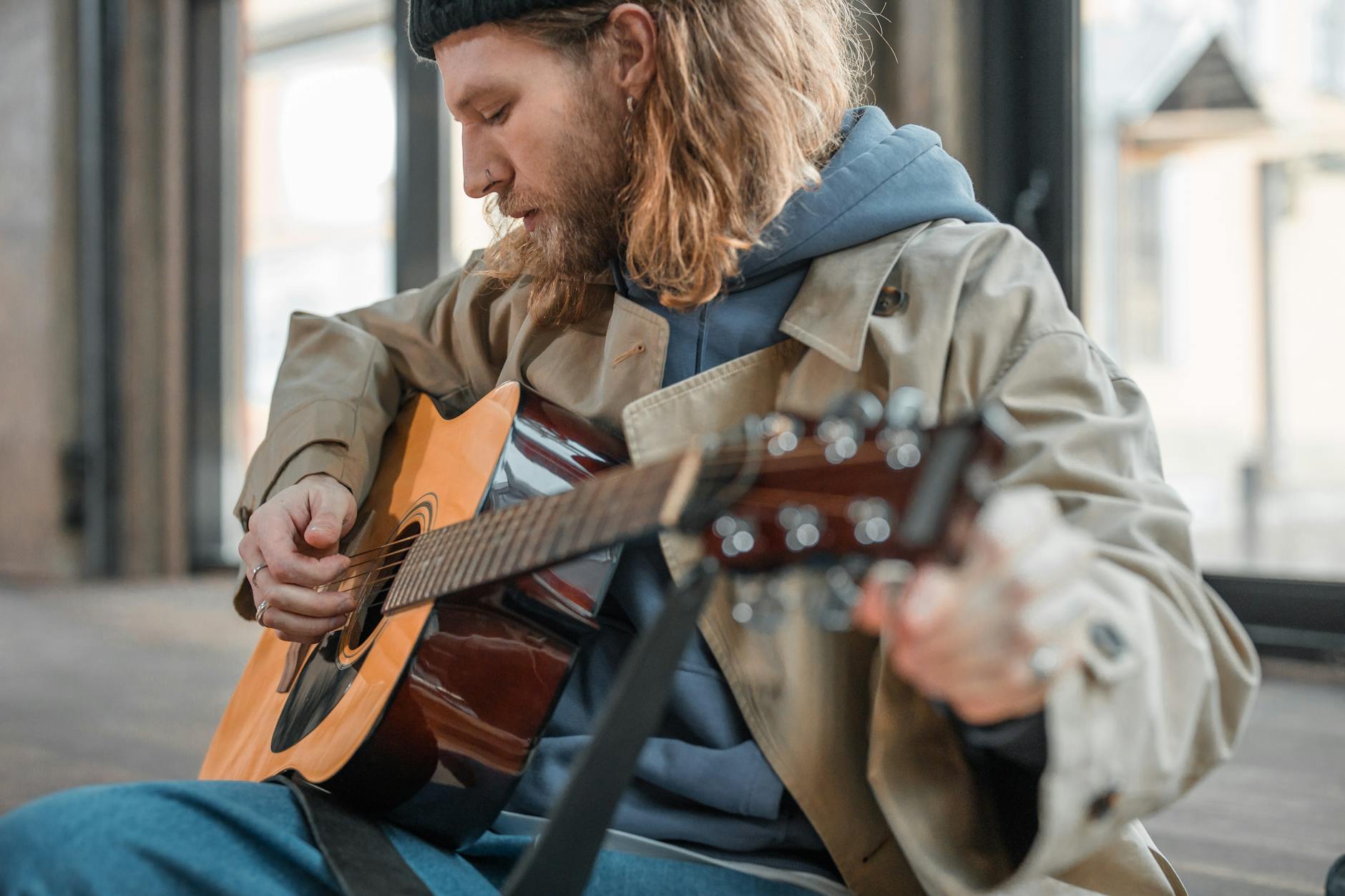 A young male musician dressed in understated casual menswear