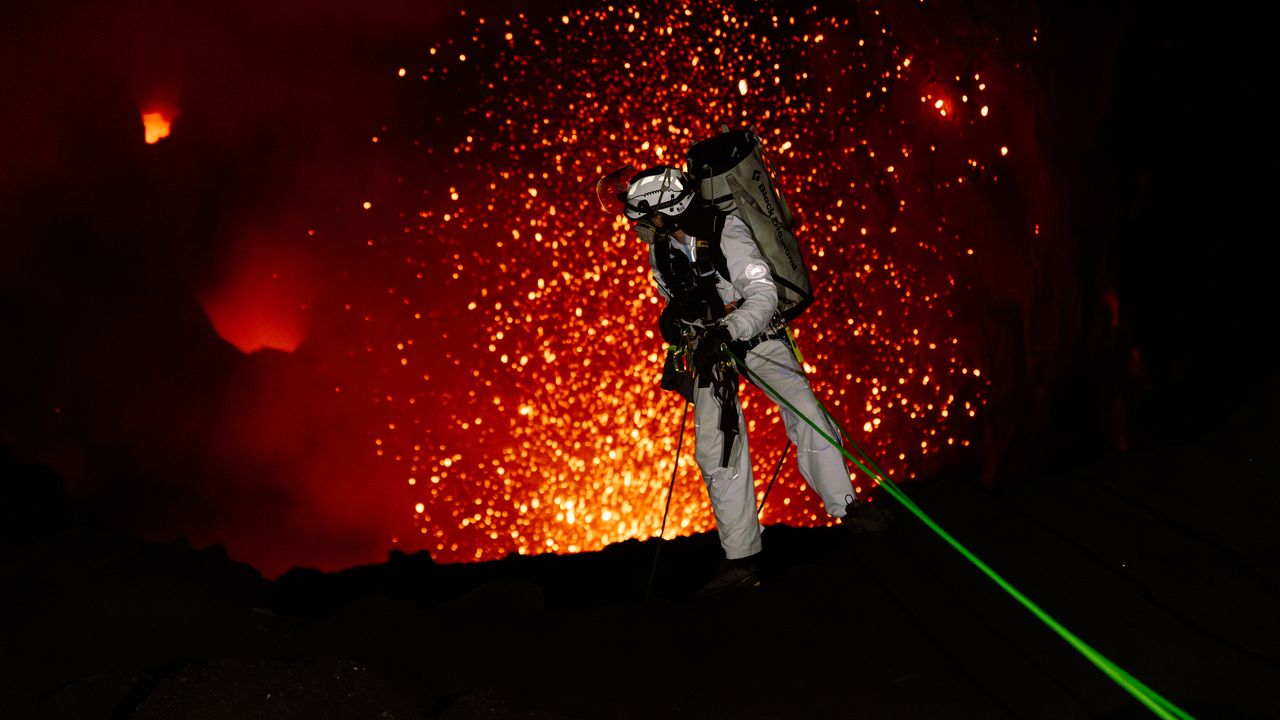 Active volcano crater with flowing lava and steam
