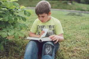 Americas Top Childrens Book Advocate Calls Most of Them Crud A young child sitting alone reading a picture book indoors