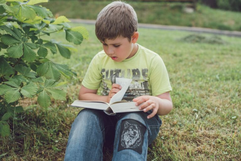 Americas Top Childrens Book Advocate Calls Most of Them Crud A young child sitting alone reading a picture book indoors