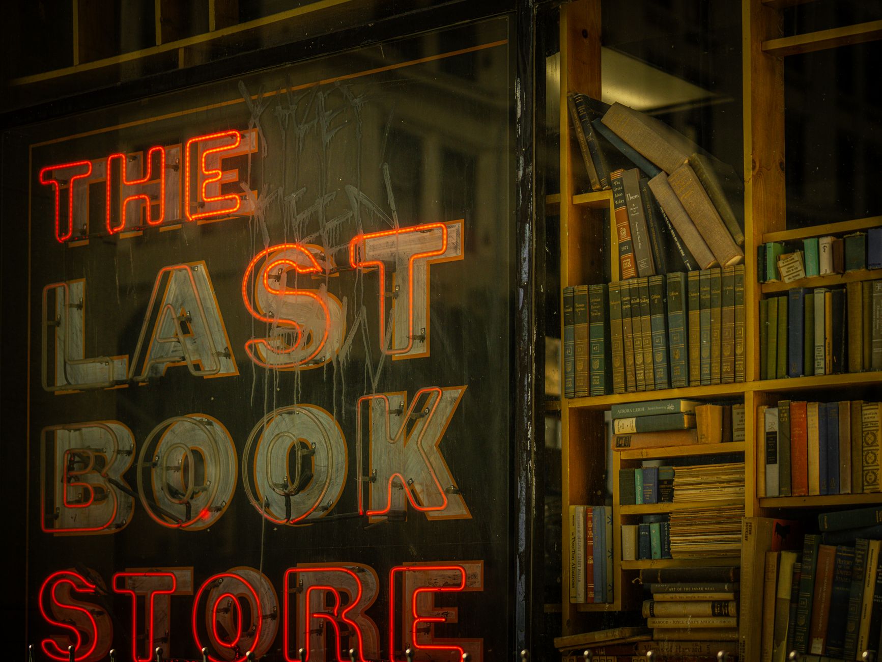 Rows of fiction titles on wooden shelves inside an independent bookstore