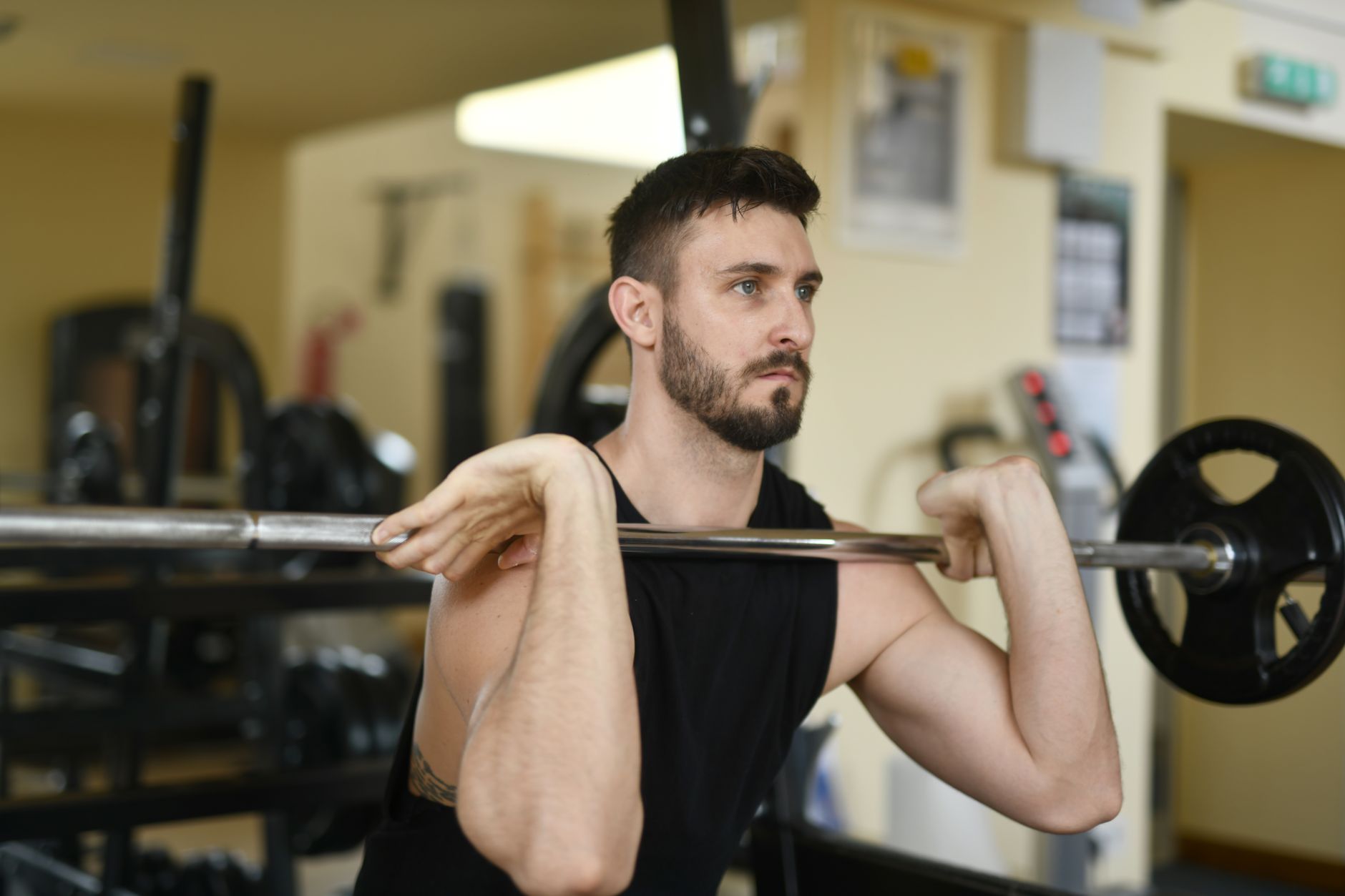 Man gripping a pull-up bar at the gym with focused expression