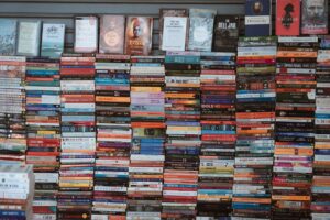 Speculative Fiction Imagines a Sapphic and Lesbian Future Stack of science fiction paperbacks on a wooden surface with dramatic lighting