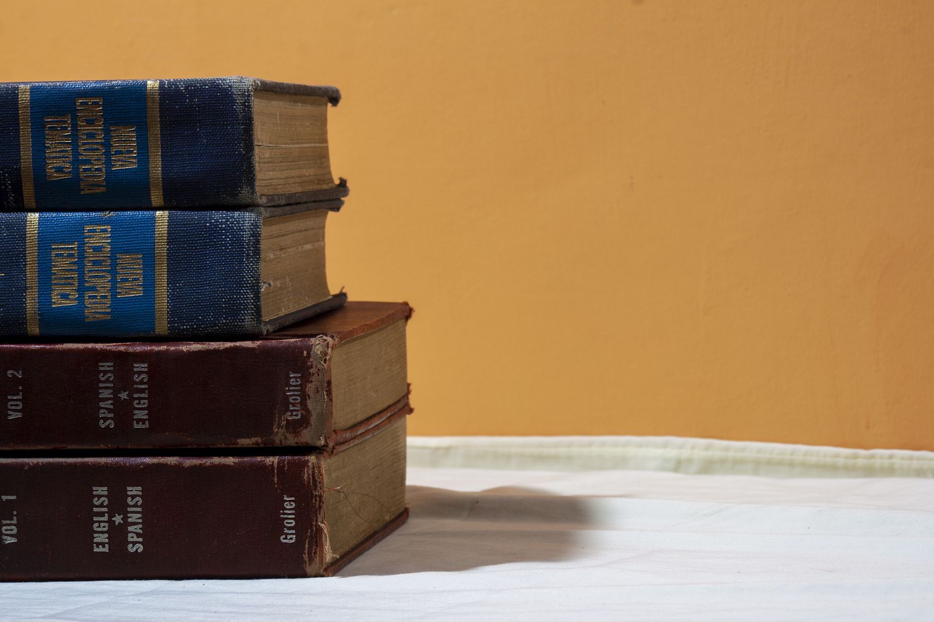 A stack of literary paperbacks including translated fiction on a wooden table