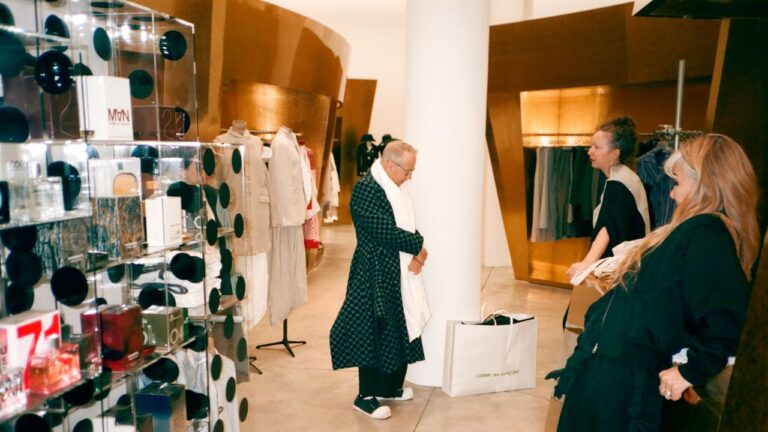 Interior of a high-end fashion boutique with minimalist displays and dark clothing racks