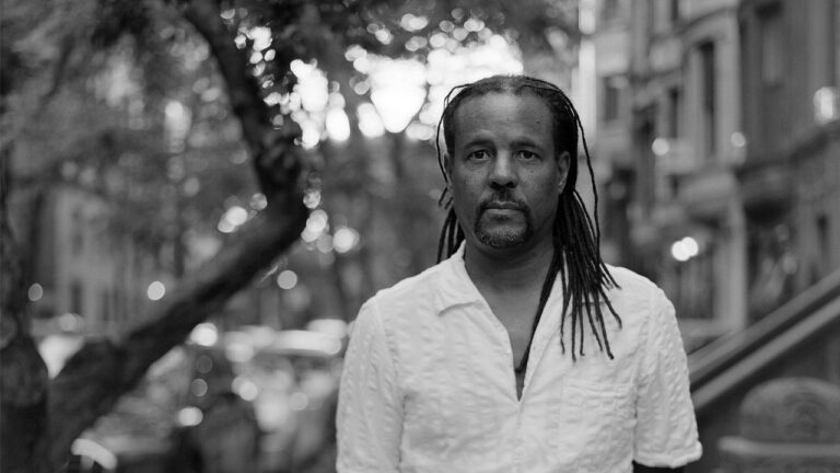 A view of a Harlem street in New York City, evoking the neighborhood setting of Colson Whitehead's crime trilogy