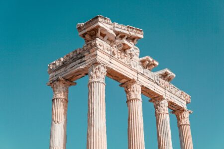 The Odysseys, ranked. Weathered stone columns at ancient Greek archaeological site under clear sky