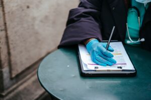 AI Enters the Prior Authorization War, and Doctors Are Alarmed A physician reviewing paperwork at a medical office desk