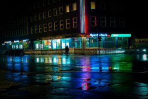 Dark neon-lit cityscape at night evoking a cyberpunk aesthetic