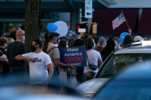 People gathered beneath an American flag at a public event