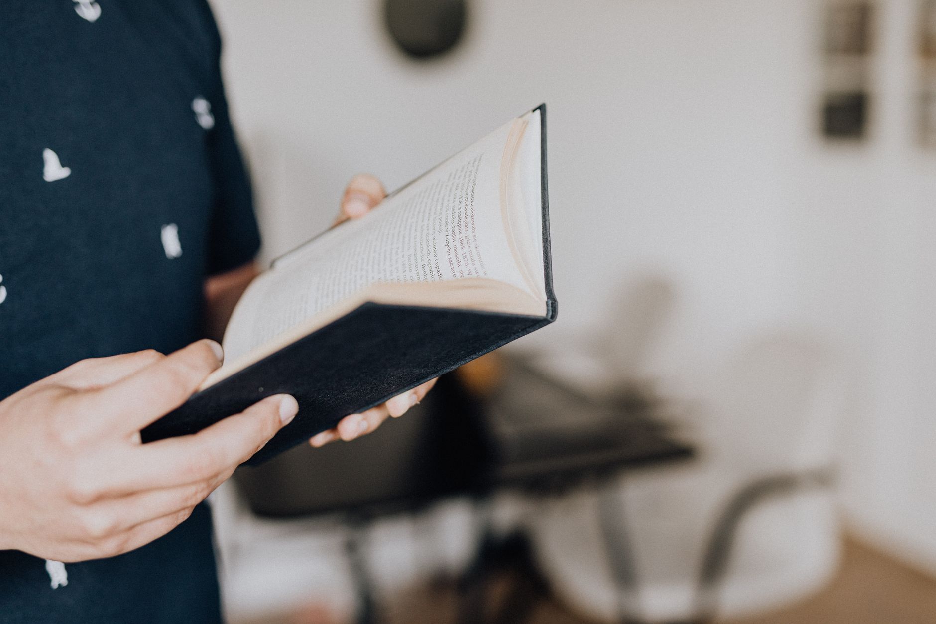 Person reading an open book with natural light