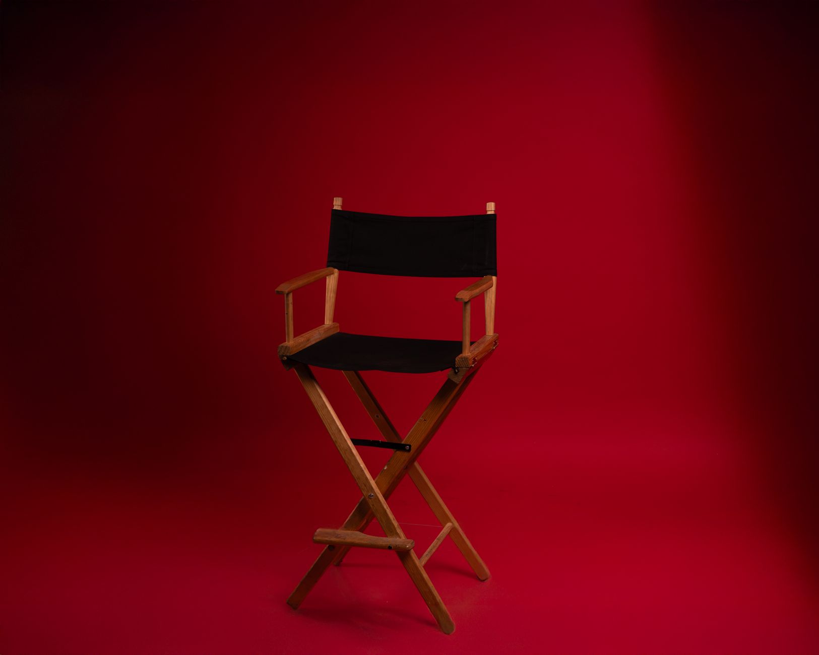 An empty director's chair on a film set with blurred background lighting