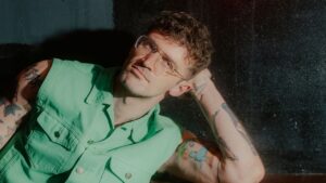 Tony Winner Sam Pinkleton Dragged Broadway Into the Sweat Empty Broadway theater stage lit with dramatic overhead lighting