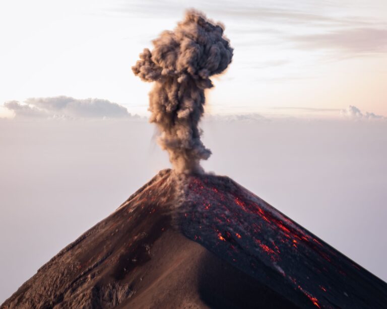 The Volcano That Was Supposed to End Us Barely Left a Mark Thick ash cloud rising from a large volcanic eruption against a dark sky