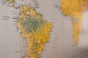 Aged world map spread open showing continents and navigation lines