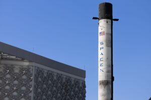 A rocket launch pad at dusk with infrastructure visible against the sky