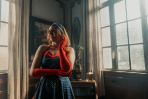 Woman in 1950s-style A-line skirt and red top, evoking mid-century American fashion