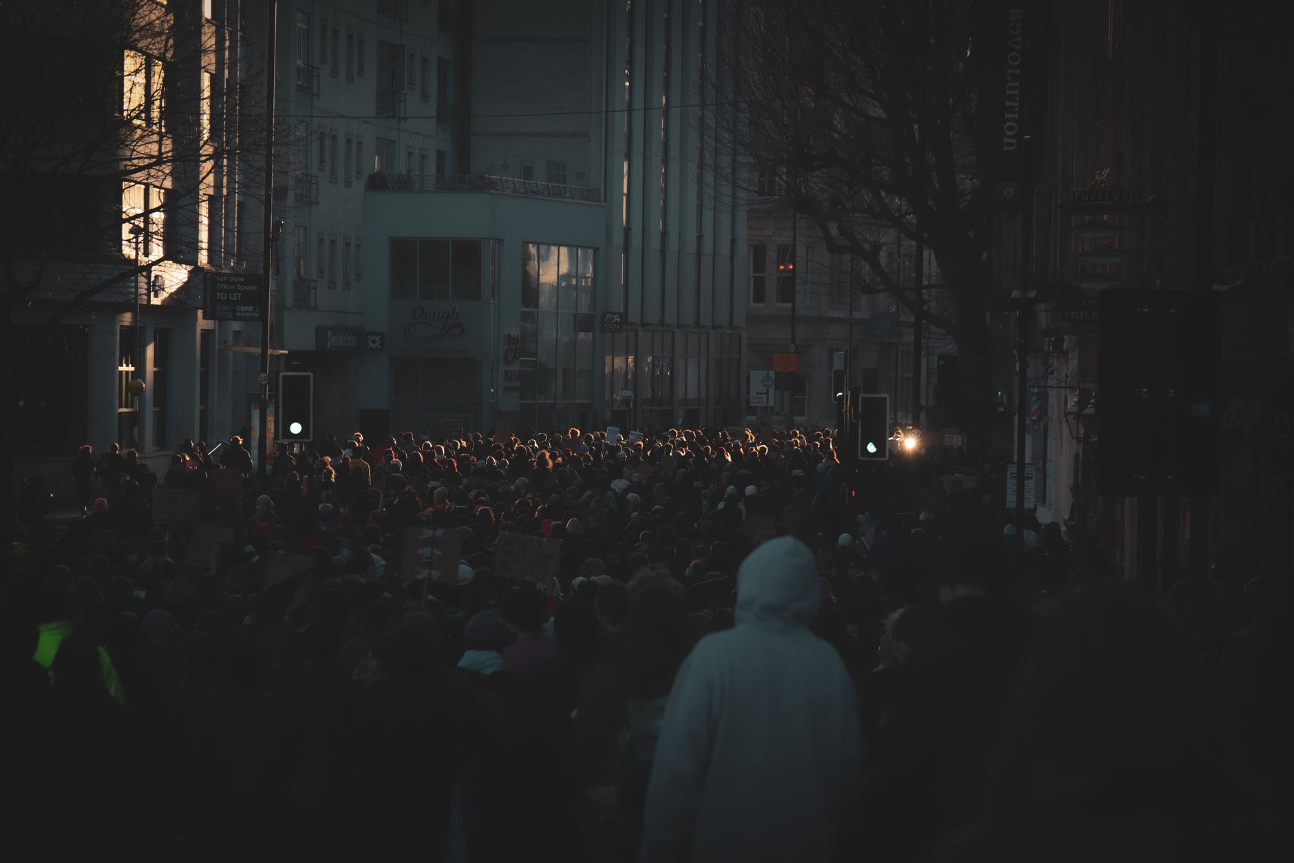 A crowd gathered at a public political rally holding signs