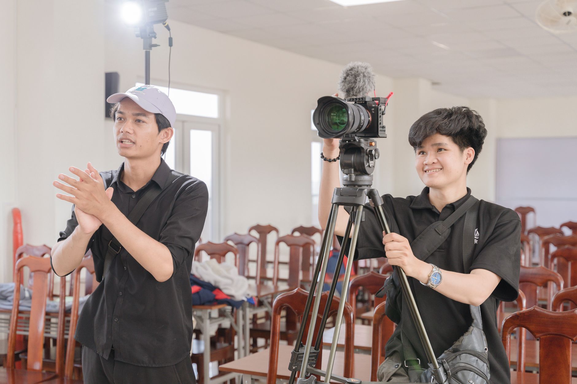 Young director behind camera on a film set with moody lighting
