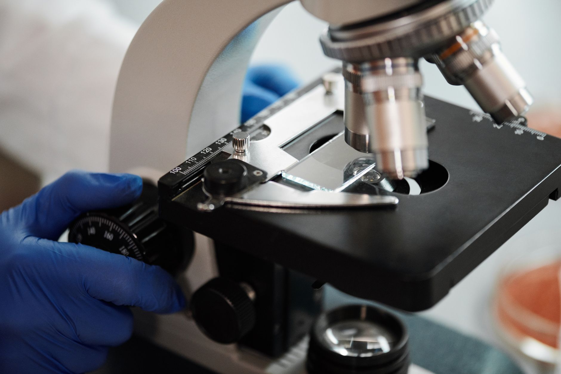 Researcher operating a microscope in a neuroscience laboratory