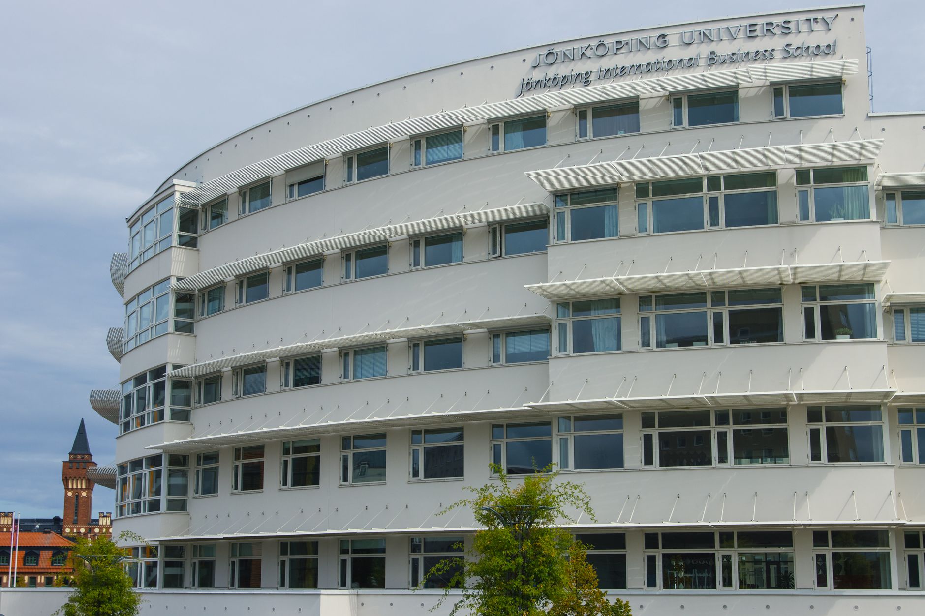 Stone university building exterior with arched windows and courtyard