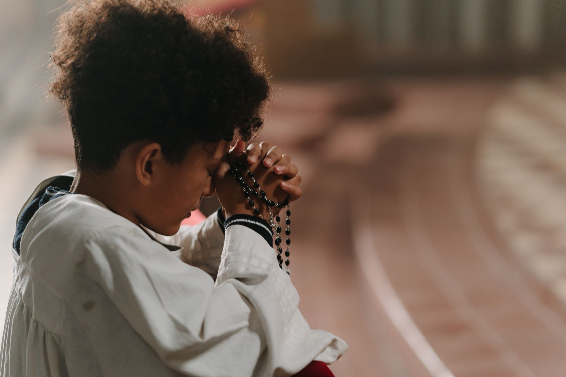 Close-up of a child's hands clasped together on a table