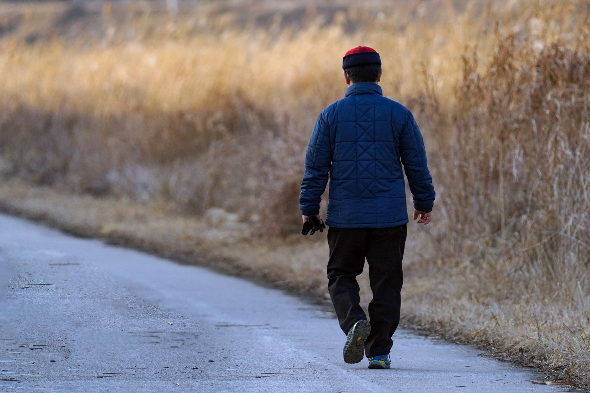 Man walking on an inclined outdoor trail as a low-impact cardio session