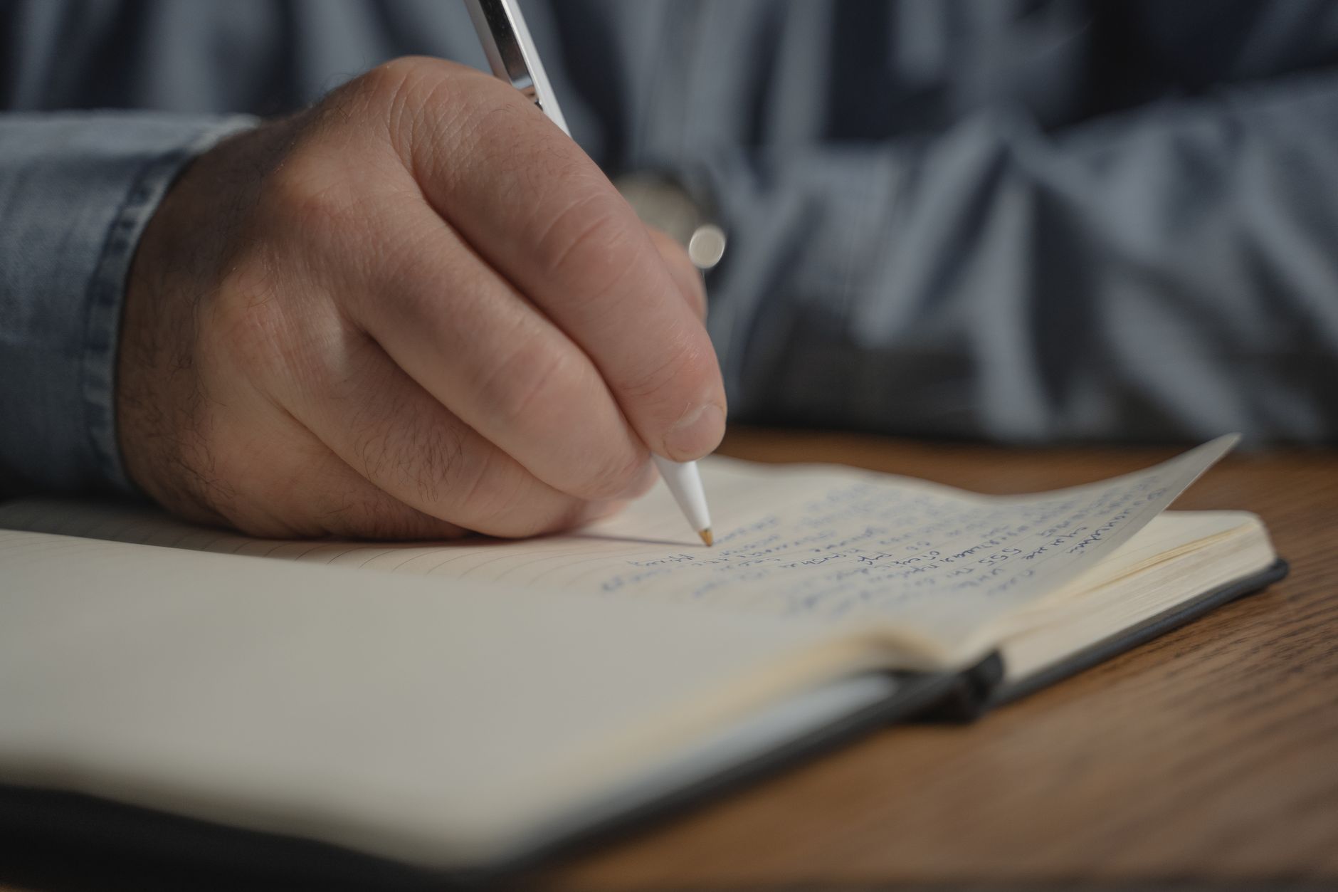 Writer's desk with open notebook and pen representing the craft of fiction writing