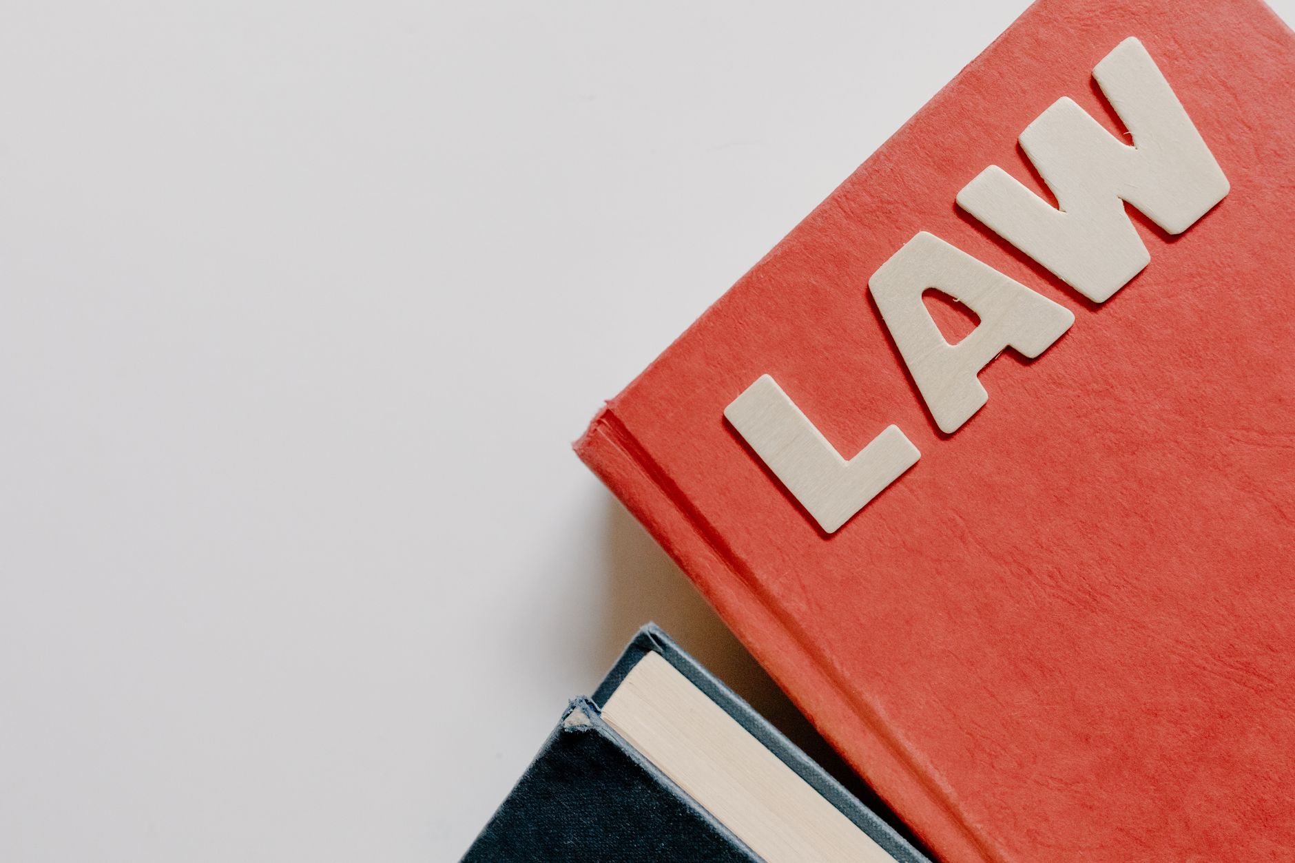 Stacked worn law books on a wooden desk representing legal history and political legacy