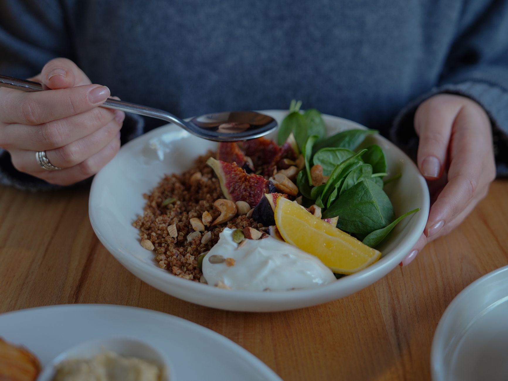 Bowl of fresh spinach and pumpkin seeds on a wooden table