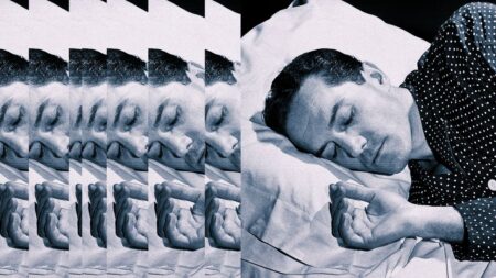 Person sleeping in a dark bedroom with white bedding