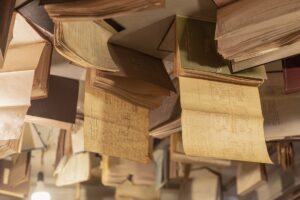Ten Books Compete for the 2026 National Book Award in Nonfiction Stack of open nonfiction books on a wooden table in a library setting