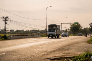Electric semi truck driving on a highway at dusk