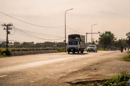 Electric semi truck driving on a highway at dusk