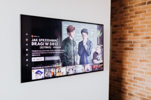 LG TV shown scanning LAN for third-party phones and other devices A large smart TV powered on in a dimly lit living room