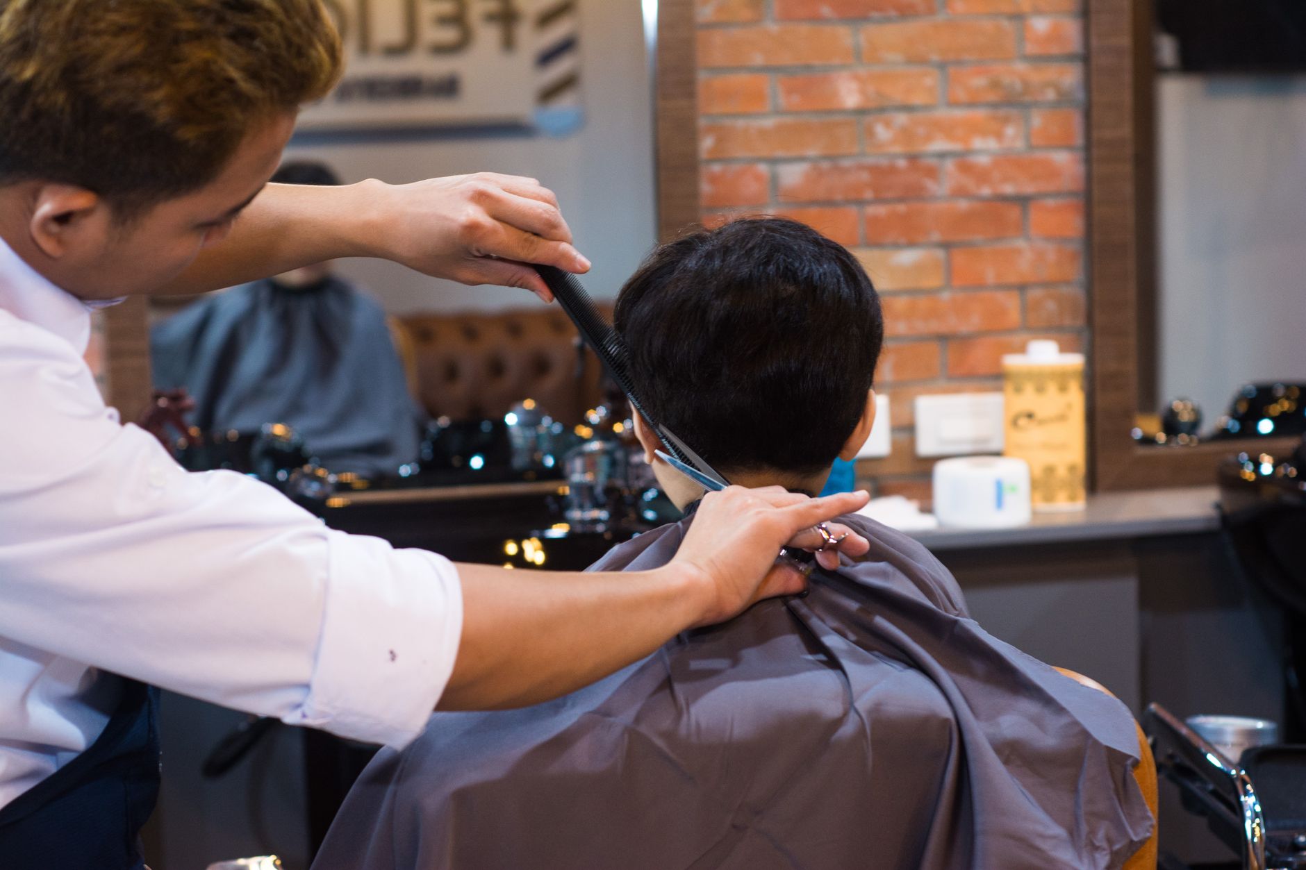 Barber working on a client's haircut in a professional barbershop setting