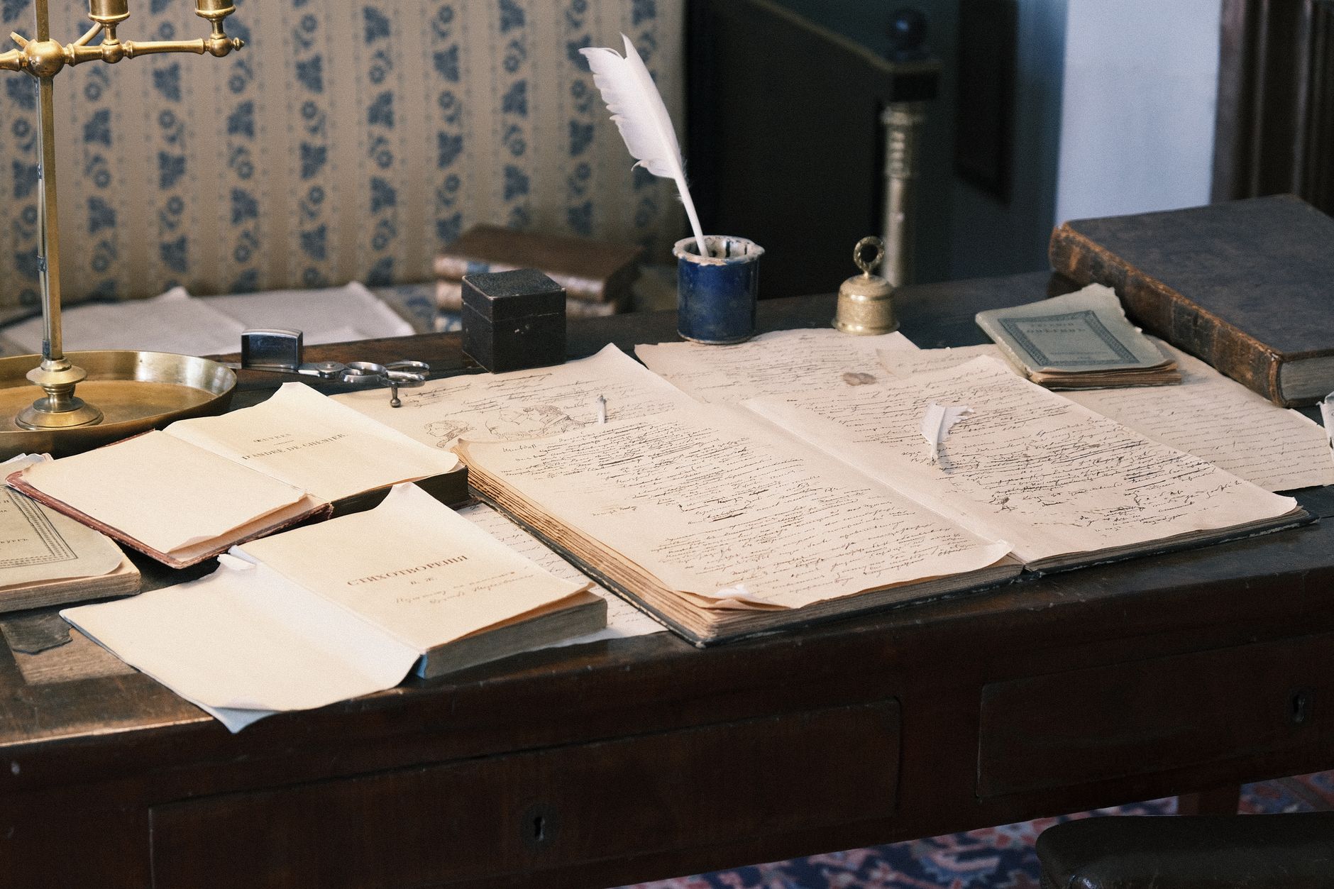 A writer's desk with papers and a manuscript under warm lamp light