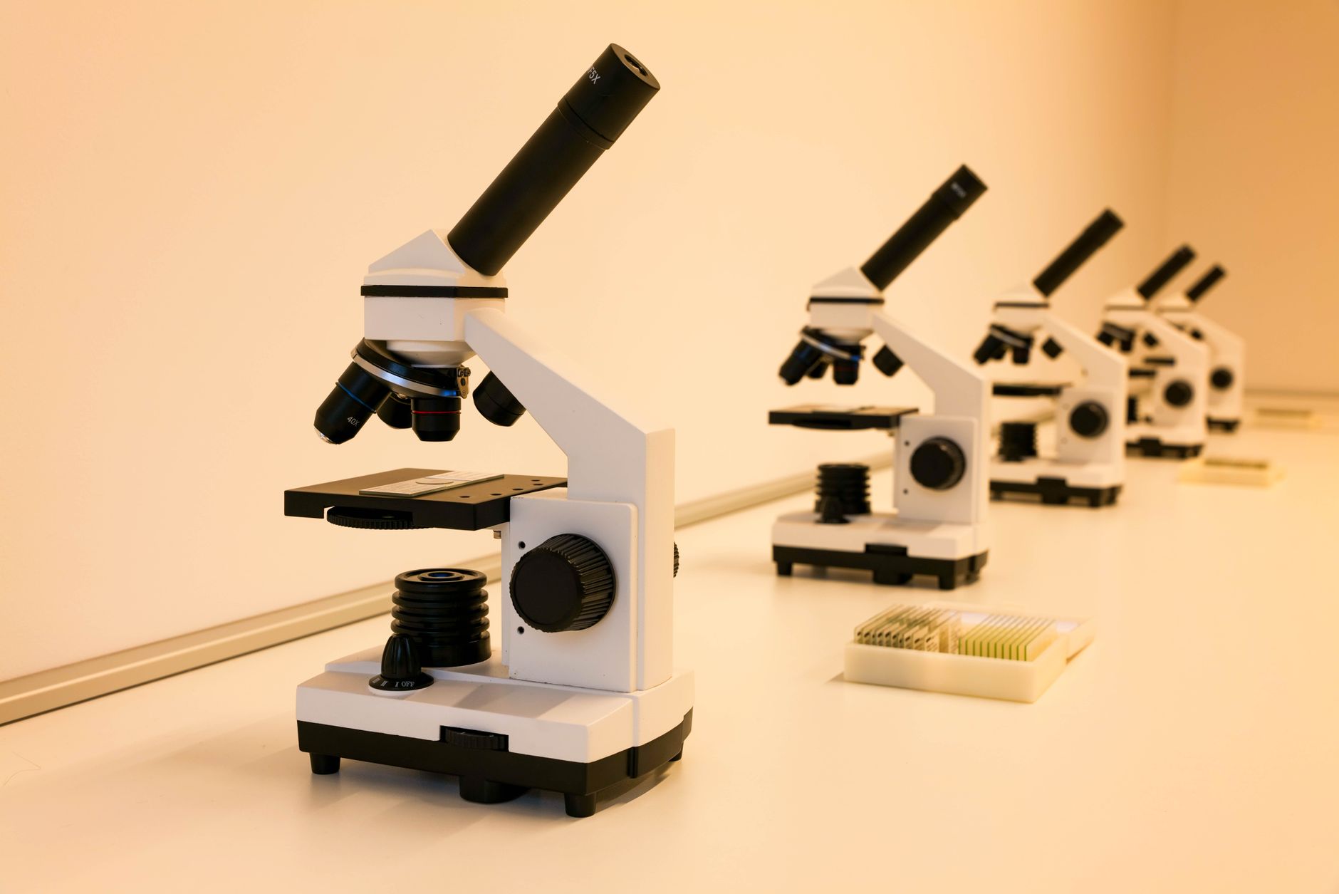 A researcher examining specimens under a microscope in a medical laboratory