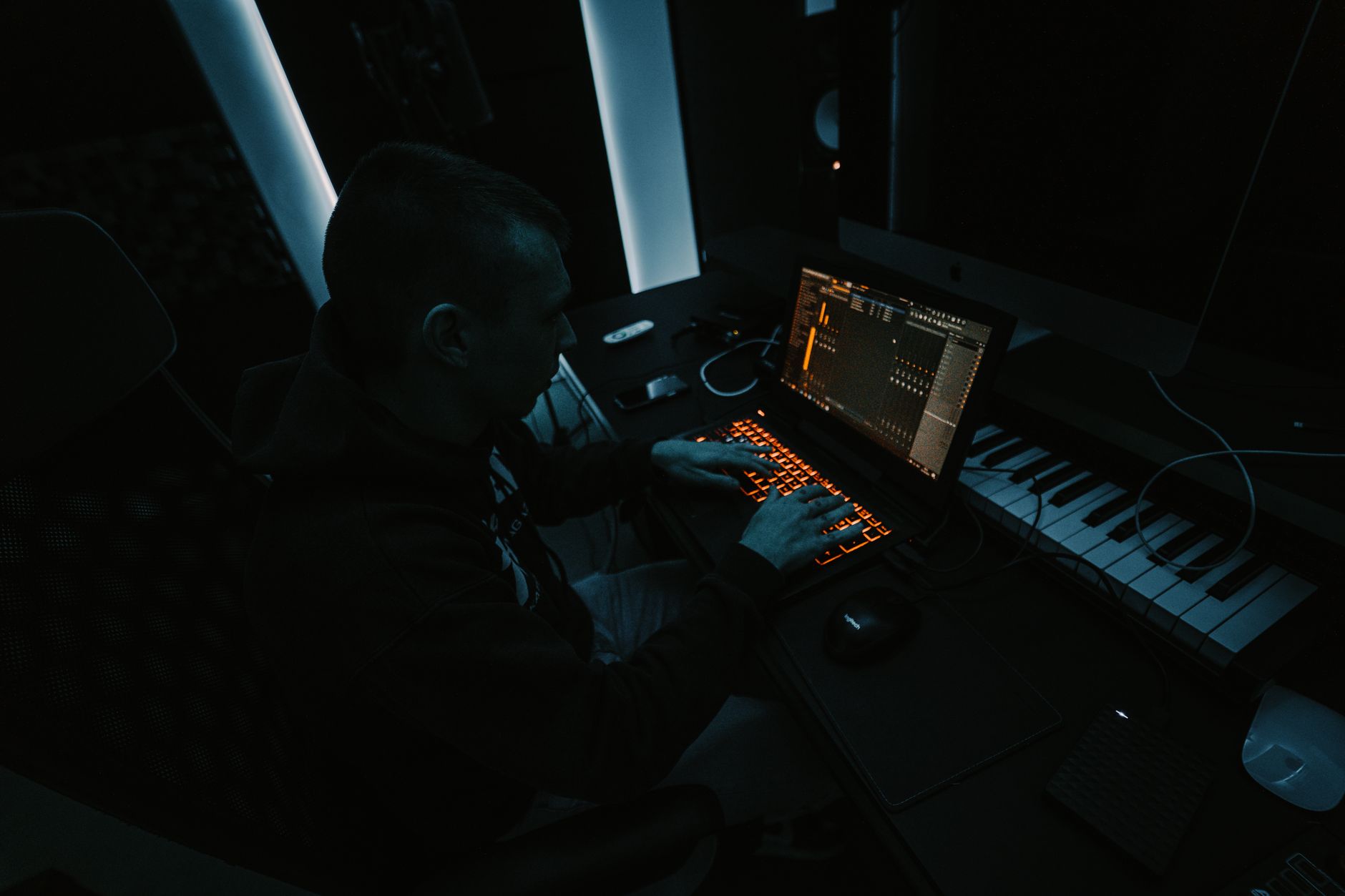 Audio production equipment in a recording studio with screens displaying waveforms
