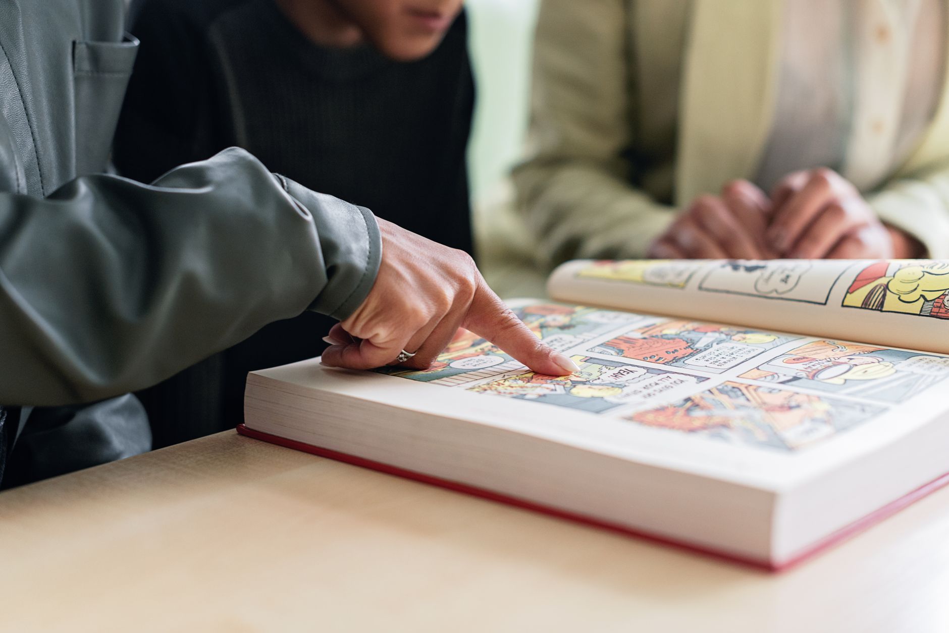 Colorful comic book panels spread open on a wooden table