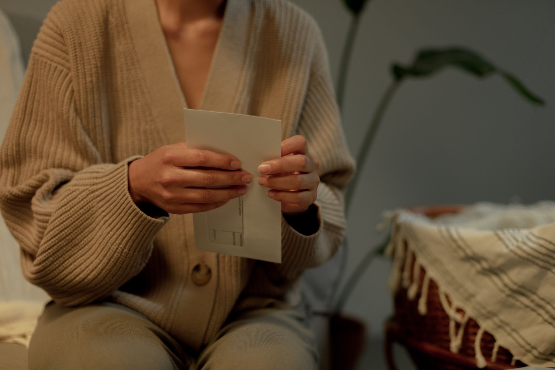 A person seated at a table reading a handwritten letter