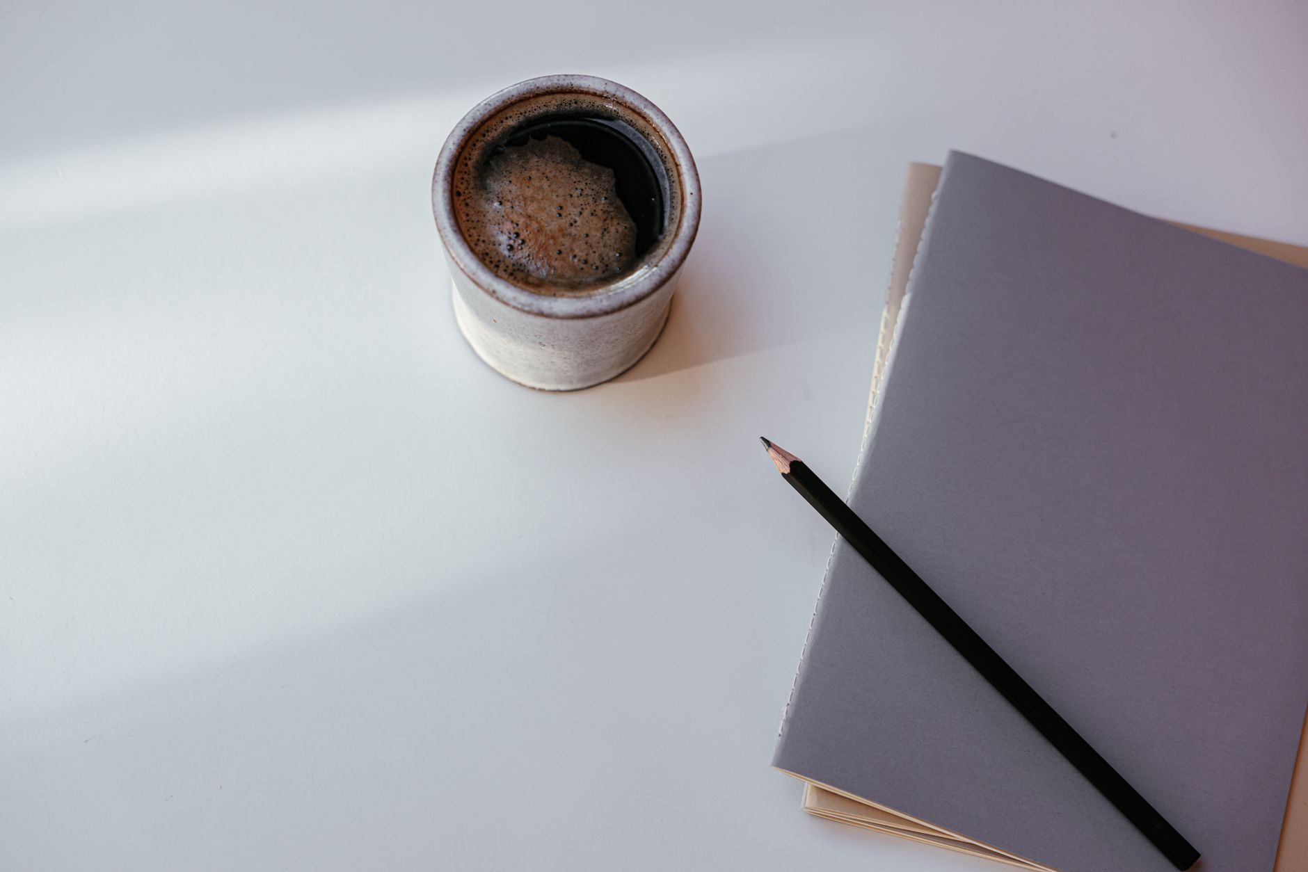 A quiet weekend desk setup with coffee and a notebook, contrasting analog planning with AI automation
